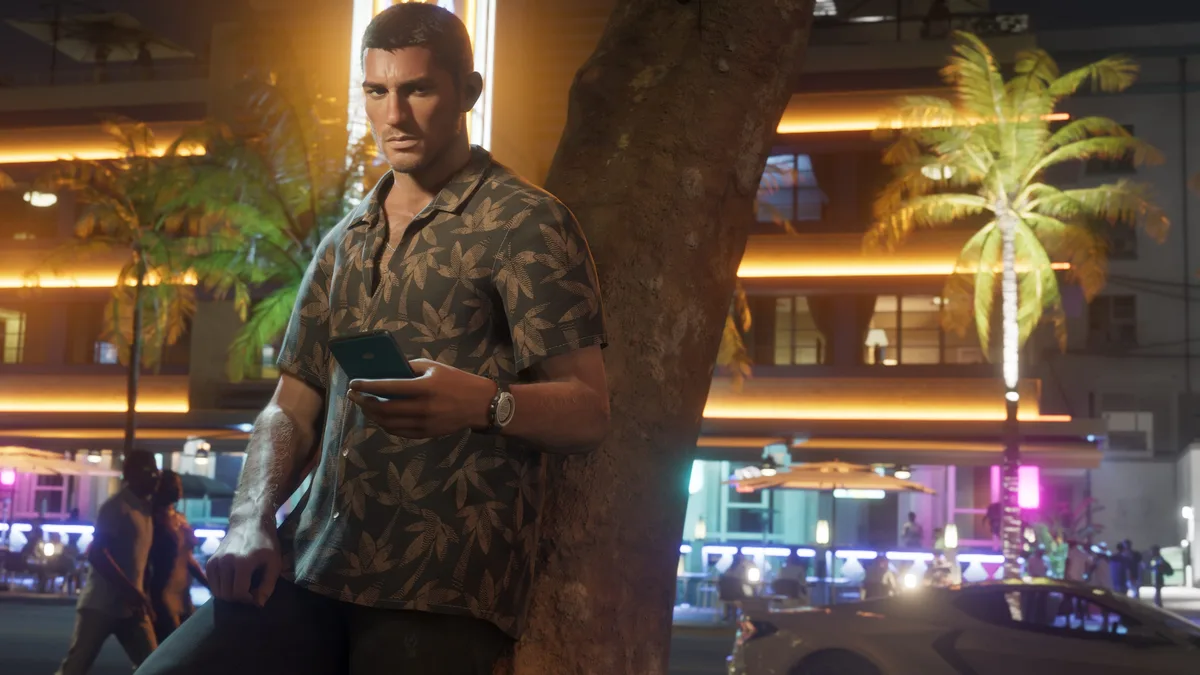 Jason Duval checks his phone on a neon lit Vice City street at night